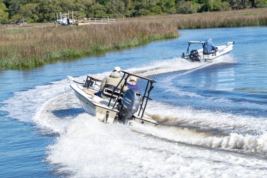 Rearview of 2 flats boats running up a creek