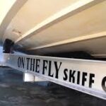 Boat trailer with On The Fly Skiff Company sticker on it